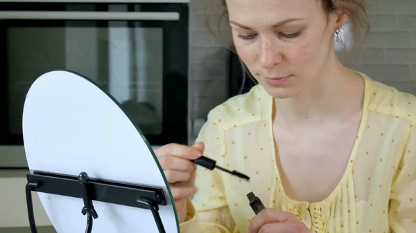 Genç güzel kadın evde bir ayna önünde makyaj. — Stok fotoğraf