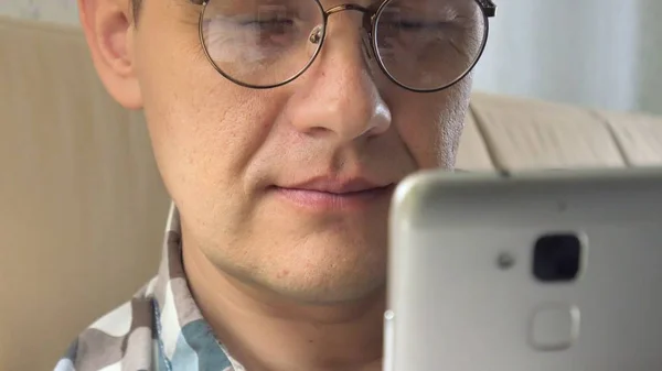 Ο άνθρωπος με τα γυαλιά του μιλά στο τηλέφωνο φτερουγίσματα το βιβλίο εσωτερικό σχεδιασμό. Κάτι ψάχνει για. Επιχειρηματικό σχέδιο. Ενθουσιώδης. Σχεδιασμός, αφηρημένη. Βολή στην κόκκινη επική κάμερα. — Φωτογραφία Αρχείου