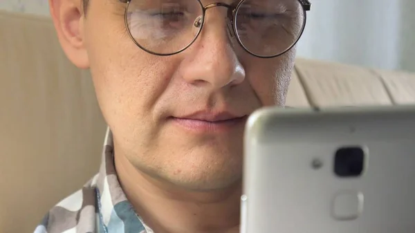 El hombre con sus gafas habla por teléfono aleteando el diseño interior del libro. Algo está buscando. Negocios de diseño. Entusiasta. Diseño, abstracto. Grabado en la cámara épica ROJA . —  Fotos de Stock