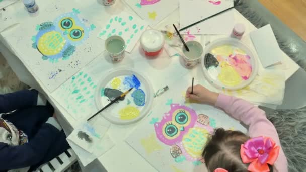 Bambini ragazzi e ragazze seduti insieme intorno al tavolo in classe e disegno . — Video Stock