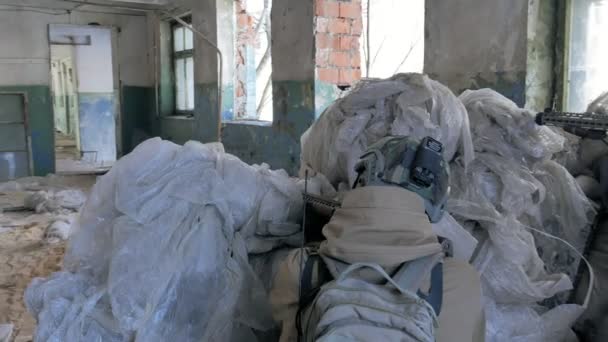 Soldados en camuflaje con armas de combate están siendo disparados en el refugio del viejo edificio, el concepto militar — Vídeos de Stock