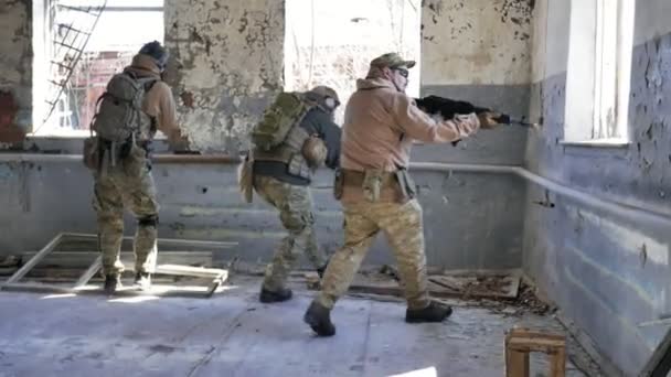 Soldaten in Tarnung mit einer Militärwaffe, die durch das Fenster eines alten Gebäudes auf das Gewehr zielte, das militärische Konzept — Stockvideo