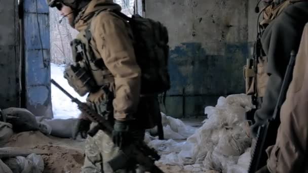 Soldados en camuflaje con armas de combate se escabullen por los pasillos del antiguo edificio, el concepto militar — Vídeo de stock