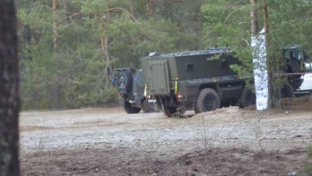 Terepszínű katonák harci fegyverekkel, az erdő közelében a csata autó, katonai koncepció — Stock videók