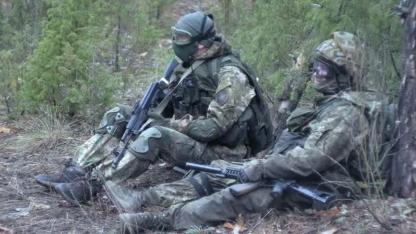 Soldados en camuflaje con armas militares descansan en el refugio del bosque, el concepto militar — Vídeo de stock
