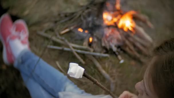 Família feliz de turistas em uma viagem. Mãe e crianças fritam marshmallows no fogo perto da tenda — Vídeo de Stock