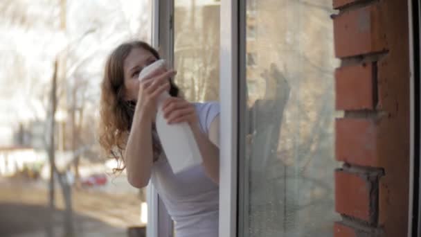 Привлекательная девушка моет окна дома. Чтобы прибраться в доме . — стоковое видео
