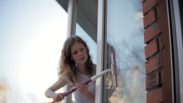 Chica atractiva lava ventanas en casa. Para limpiar la casa . — Vídeo de stock