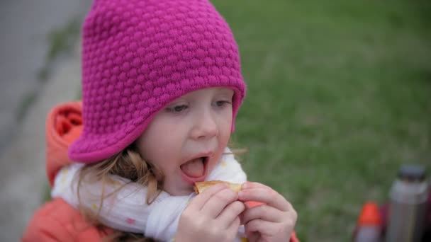 Ein hübsches kleines Mädchen und ihre Mutter essen Pizza im Freien. Ernährung, Ernährung und Lebensstil — Stockvideo