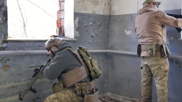 Солдаты в камуфляже с военным оружием, нацеленным через прицел винтовки через окно старого здания, военная концепция — стоковое видео