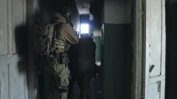 Soldaten in camouflage met bestrijding wapens sluipen langs de gangen van het oude gebouw, het militaire concept — Stockvideo