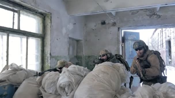 Soldados en camuflaje con armas de combate están siendo disparados en el refugio del viejo edificio, el concepto militar — Vídeos de Stock