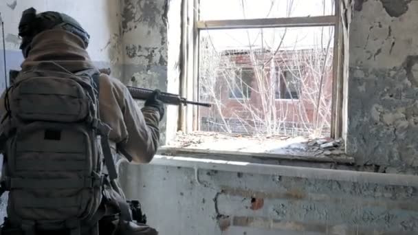 Vojáci v maskování vojenských zbraní, jejichž prostřednictvím puška pohled oknem staré budovy, vojenský koncept — Stock video