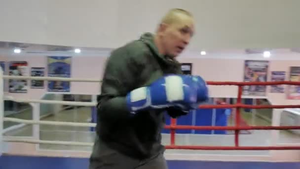 The trainer conducts a training battle with a female kickboxer in the ring — Stock Video