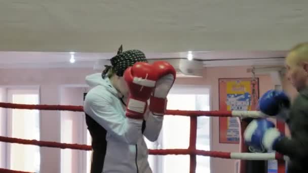 L'allenatore conduce una battaglia di allenamento con una kickboxer donna sul ring — Video Stock