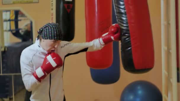 Boxerin trainiert Boxsack im Fitnessstudio heftige Kraftsport-Body-Kickboxer-Serie — Stockvideo