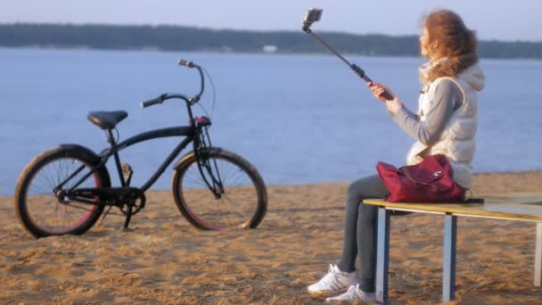 Bonita sonrisa chica tomar uno mismo foto selfie con teléfono inteligente móvil en la orilla del río — Vídeos de Stock