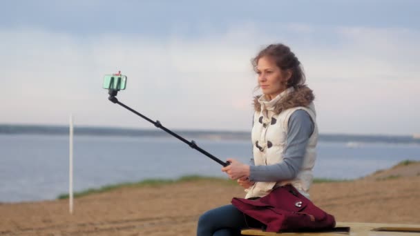 美少女の笑顔は 川の銀行 スマート フォン モバイルと自己映像 Selfie — ストック動画