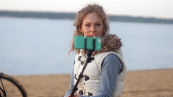 Söt flicka leende ta själv föreställer selfie med smart telefon mobil på Älvstranden — Stockvideo