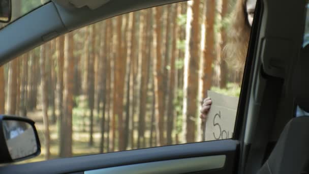Joven hermosa mujer autostop de pie en la carretera con una mochila en una mesa con una inscripción SUR — Vídeos de Stock