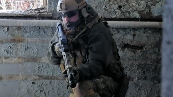 Soldaten in camouflage met een militaire wapen gericht door middel van het geweer zicht door het raam van een oud gebouw, het militaire concept — Stockvideo