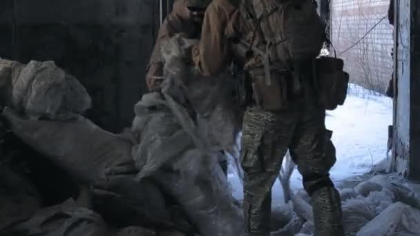 Soldati in camuffamento con armi da combattimento si intrufolano lungo i corridoi del vecchio edificio, il concetto militare — Video Stock