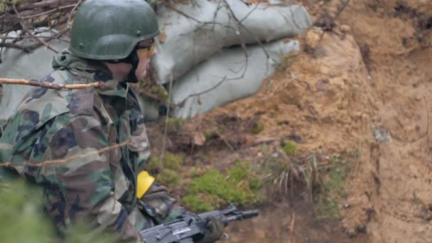 Солдаты в камуфляже с боевым оружием стреляют в укрытии леса, военная концепция — стоковое видео