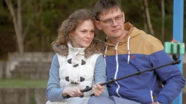 Muž fnd žena úsměv si vlastní obrázek selfie s chytrý telefon mobilní na park — Stock video