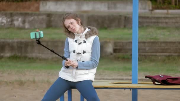 Bonita sonrisa chica tomar uno mismo foto selfie con teléfono inteligente móvil en la orilla del río — Vídeo de stock