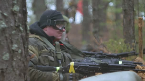 Військовослужбовців у камуфляжі з бойовою зброєю обстрілюють у притулку лісу, військова концепція — стокове відео