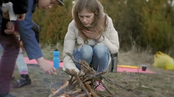 Glückliche Familie von Touristen auf einer Reise. Mutter und Kinder entfachen Feuer — Stockvideo