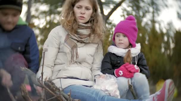 Šťastná rodina turistů na cestě. Máma a děti smažit marshmallows hoří u stanu — Stock video