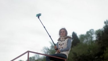 güzel kız gülümseme almak kendi kendine resim selfie akıllı telefon mobil ile park 4k