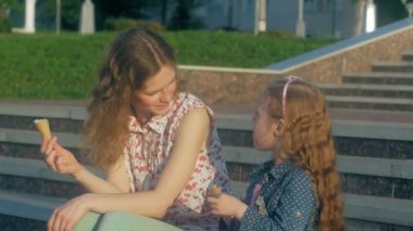 Anne ve kızı bir parkta dondurma yemek. Anne ve çocuk. mutlu aile rahatlatıcı