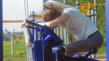 Genç fitness kadının park açık spor salonunda egzersizleri yapması
