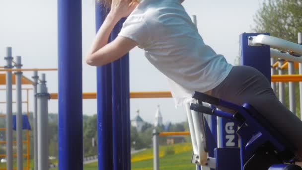 Joven mujer de fitness haciendo ejercicios en el gimnasio en un parque al aire libre — Vídeos de Stock