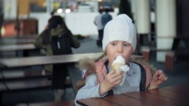 Beyaz örgü şapkalı dondurma yemek şirin bebek kız