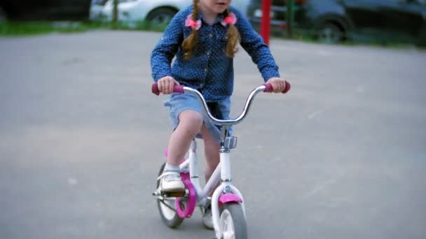 Lilla vackra flicka rider en cykel — Stockvideo