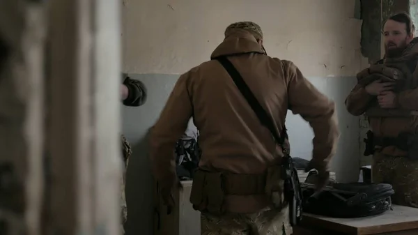 Soldaten in Tarnkleidung bereiten sich auf den Kampf vor und prüfen Ausrüstung und Waffen — Stockfoto
