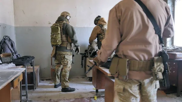 Soldaten in Tarnkleidung bereiten sich auf den Kampf vor und prüfen Ausrüstung und Waffen — Stockfoto