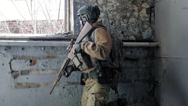 Soldaten in Tarnung mit einer Militärwaffe, die durch das Fenster eines alten Gebäudes auf das Gewehr zielte, das militärische Konzept — Stockfoto