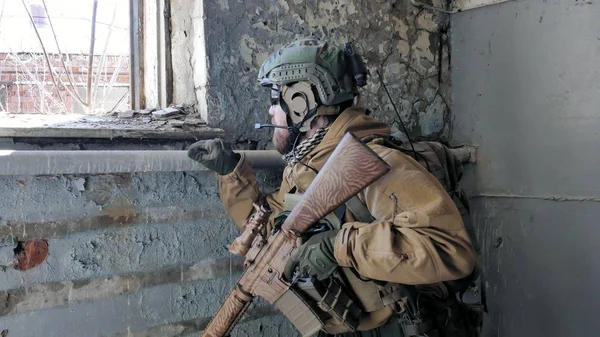 Soldati in camuffamento con un'arma militare che mira attraverso la vista del fucile attraverso la finestra di un vecchio edificio, il concetto militare — Foto Stock