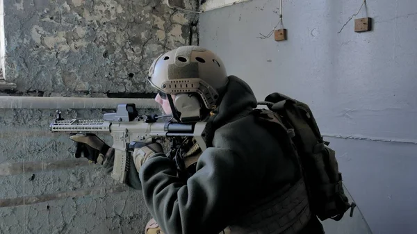 Soldaten in Tarnung mit einer Militärwaffe, die durch das Fenster eines alten Gebäudes auf das Gewehr zielte, das militärische Konzept — Stockfoto