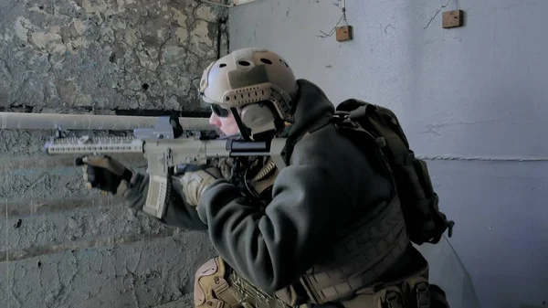 Soldaten in Tarnung mit einer Militärwaffe, die durch das Fenster eines alten Gebäudes auf das Gewehr zielte, das militärische Konzept — Stockfoto