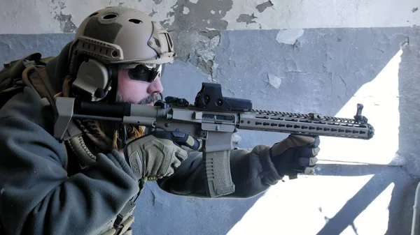 Soldados en camuflaje con un arma militar apuntando a través de la mira del rifle a través de la ventana de un viejo edificio, el concepto militar —  Fotos de Stock