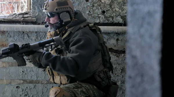 Soldados en camuflaje con un arma militar apuntando a través de la mira del rifle a través de la ventana de un viejo edificio, el concepto militar —  Fotos de Stock