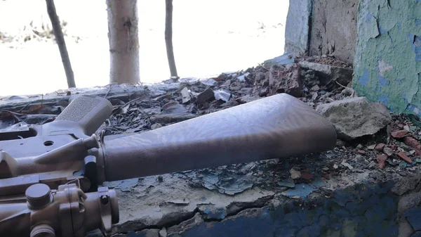 El rifle yace en el alféizar de un edificio en ruinas — Foto de Stock