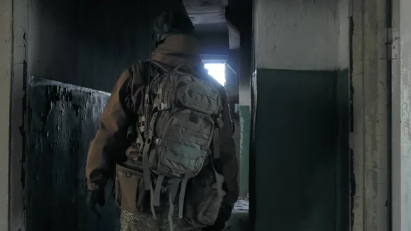 Soldados en camuflaje con armas de combate se escabullen por los pasillos del antiguo edificio, el concepto militar — Foto de Stock