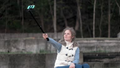 güzel kız gülümseme almak kendi kendine resim selfie akıllı telefon ile mobil bulunan Parkı