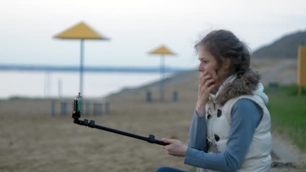 Bonita sonrisa chica tomar uno mismo foto selfie con teléfono inteligente móvil en la orilla del río — Vídeo de stock